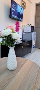 a vase with flowers sitting on a table in an office at The cozy nook - Thindigua in Kiambu