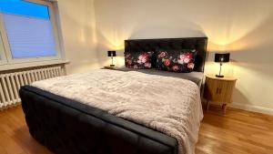 a bedroom with a large bed with two lamps at Sylter Seestern App Ankerplatz in Morsum