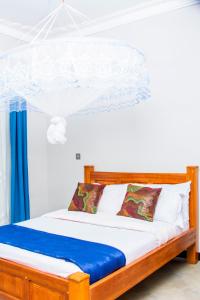 een slaapkamer met een bed met een blauwe en witte baldakijn bij Mufasha Boutique Suites in Kisoro