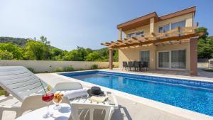 eine Villa mit Swimmingpool und ein Haus in der Unterkunft Villa Ivan by Villas Guide in Primorski Dolac