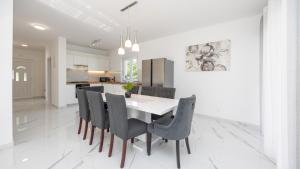 eine weiße Küche mit einem Esstisch und Stühlen in der Unterkunft Villa Ivan by Villas Guide in Primorski Dolac