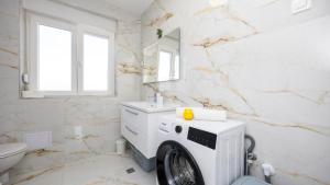ein weißes Bad mit einer Waschmaschine in der Unterkunft Villa Ivan by Villas Guide in Primorski Dolac