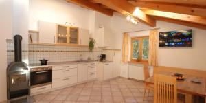 a kitchen with white cabinets and a table and a stove at Ferienwohnung BERGKLANG in Nova Ponente