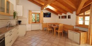 a kitchen with a table and a dining room at Ferienwohnung BERGKLANG in Nova Ponente
