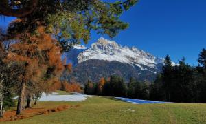 a snow covered mountain in the middle of a field at Ferienwohnung BERGKLANG in Nova Ponente