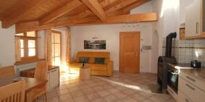a kitchen and living room with a couch in it at Ferienwohnung BERGKLANG in Nova Ponente +5 photos