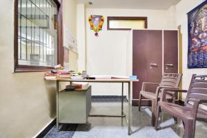 ein Klassenzimmer mit einem Schreibtisch, Stühlen und einem Kühlschrank in der Unterkunft Hotel O Santosh Seva Sadan in Rāiwāla