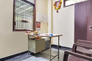 ein Schreibtisch in einem Klassenzimmer mit Fenster in der Unterkunft Hotel O Santosh Seva Sadan in Rāiwāla