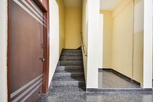 ein Flur mit Treppe, die zu einer Tür führt in der Unterkunft Hotel O Santosh Seva Sadan in Rāiwāla