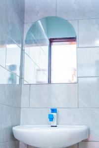 een badkamer met een wastafel en een spiegel bij Mufasha Boutique Suites in Kisoro +22 foto's