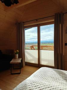 a bedroom with a bed and a large window at Domek z Sercem in Pieniążkowice