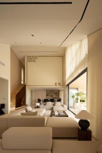 een woonkamer met witte banken en een groot scherm bij KW 2 Villa in Ban Bang Po