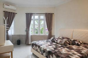 ABC Homestay في Sentool: غرفة نوم مع سرير وبطانية مقلية ونافذة