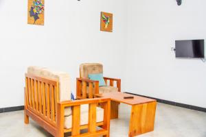een woonkamer met twee stoelen en een tafel bij Mufasha Boutique Suites in Kisoro