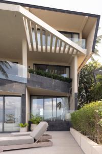 een huis met een witte stoel ervoor bij KW 2 Villa in Ban Bang Po +38 foto's