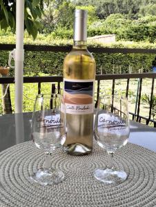 een fles wijn en twee wijnglazen op een tafel bij Gite emilouise in Carnoules