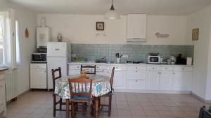een keuken met een tafel en stoelen en een witte koelkast bij Gite emilouise in Carnoules