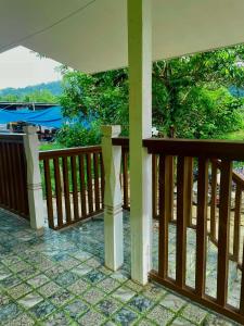a wooden railing on a porch with a view at Kenji Guest House in San Vicente