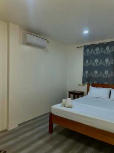 a bedroom with a bed with a blue and white wall at Kenji Guest House in San Vicente +13 photos