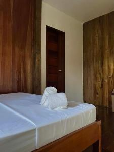 a bed with two towels sitting on top of it at Kenji Guest House in San Vicente