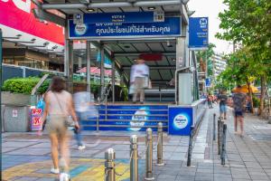 un gruppo di persone che camminano davanti a un edificio di Best Western Ratchada Hotel a Bangkok