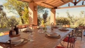 a table with wine glasses and plates on a patio at Pool Villa With Animals Near Sutri in Sutri