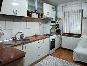 a kitchen with white cabinets and a sink at La Montzi For4 in Craiova
