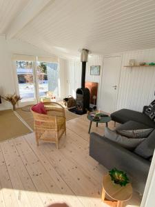 un soggiorno con divano e camino di Summer Bliss With Vibrant Garden In Nødebohuse a Kikhavn