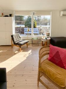 un soggiorno con un divano e una sedia di Summer Bliss With Vibrant Garden In Nødebohuse a Kikhavn