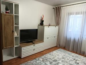 a living room with a television on a white cabinet at La Montzi For4 in Craiova