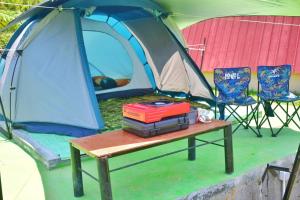 une pile de livres sur une table devant une tente dans l'établissement Khanzana Cabin and Camp Telaga Menjer, à Kejajar