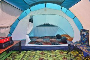 une chambre avec un lit dans une tente dans l'établissement Khanzana Cabin and Camp Telaga Menjer, à Kejajar
