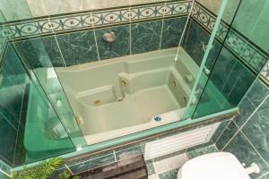 a bathroom with a bath tub with a toilet at Recanto aconchego in Peruíbe