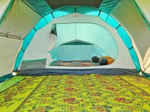 une personne allongée à l'intérieur d'une tente dans l'établissement Khanzana Cabin and Camp Telaga Menjer, à Kejajar