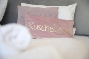 Ein Kissen mit dem Wort K küsste mich, während ich auf einem Bett saß. in der Unterkunft Urban Exit Weiden West A93 in Weiden