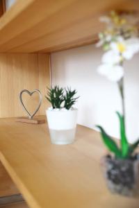 ein Regal mit zwei Pflanzen und einem Herz darauf in der Unterkunft Urban Exit Weiden West A93 in Weiden
