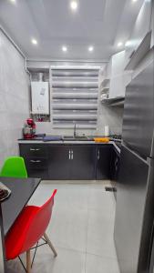een keuken met een rode stoel en een wastafel bij Confort, propreté et tranquillité à Alger centre in Alger
