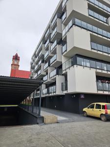 a building with a yellow car parked in front of it at Apartament Dobra Nocka 2 in Przeworsk