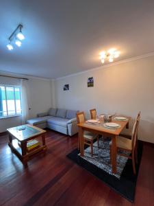 a living room with a table and a couch at Casa Do Arco - Machico Centre with Private Balconies and Parking in Machico