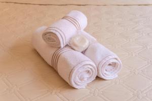 een stapel witte handdoeken op een bed bij Recanto aconchego in Peruíbe +62 foto's