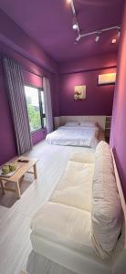 ein Schlafzimmer mit zwei Betten und einer lila Wand in der Unterkunft 陌野輕旅民宿 in Xiulin