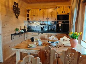 a kitchen with a table with a cake on it at Domek z Sercem in Pieniążkowice