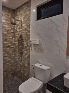 een badkamer met een wit toilet en een wastafel bij Kalih Homestay Bali in Kuta