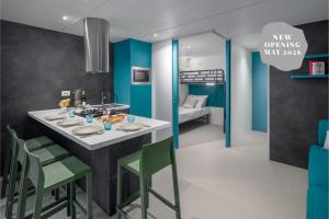 een keuken met een tafel en stoelen en een bed bij Boutique Camping Materada Beach in Poreč +35 foto's