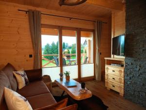 a living room with a couch and a large window at Domek z Sercem in Pieniążkowice