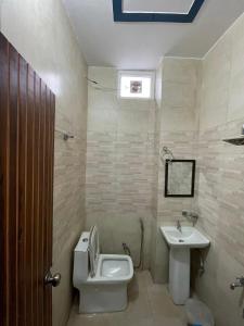 een badkamer met toilet en wastafel bij Hotel Himalayan Residency in Jāmb +19 foto's