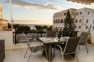 eine Terrasse mit Tisch und Stühlen auf einem Balkon in der Unterkunft Sunny home crete in Ierápetra