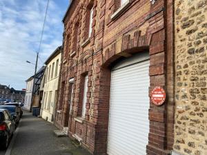 een garagedeur aan de zijkant van een bakstenen gebouw bij Le rêve de Jocelyne - Grande maison au Neubourg in Le Neubourg