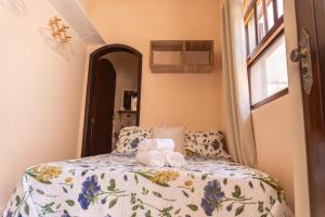 een slaapkamer met een bed met handdoeken erop bij Recanto aconchego in Peruíbe