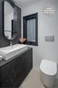 een badkamer met een wastafel, een toilet en een spiegel bij Boutique Camping Materada Beach in Poreč